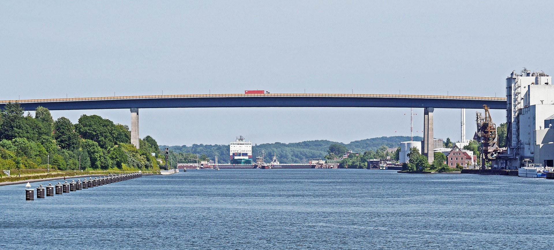 Der nord-ostsee-kanal mit einer Brücke an einem wolkenlosen Tag.