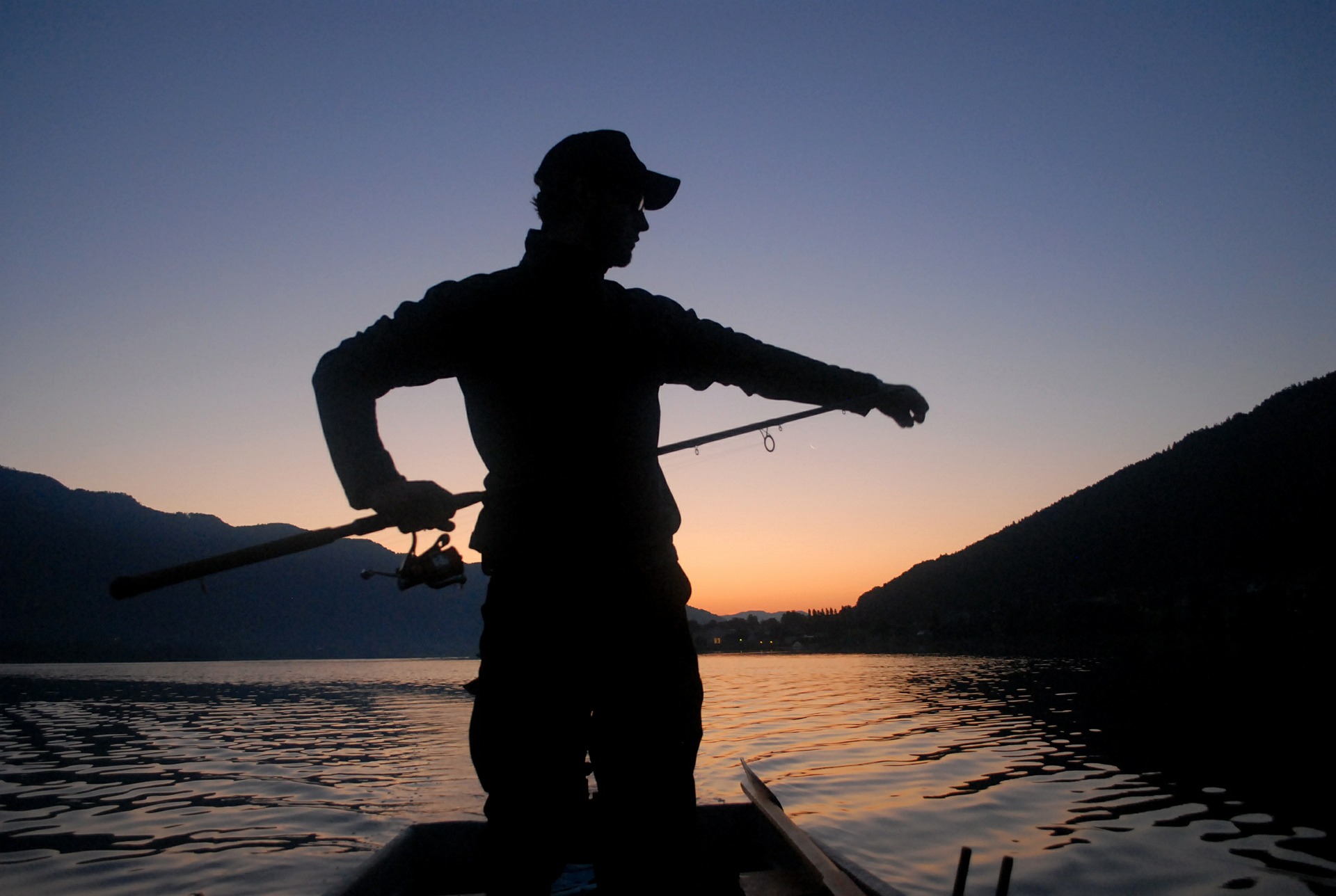 Ein Angler beim angeln mit sonnenuntergang.