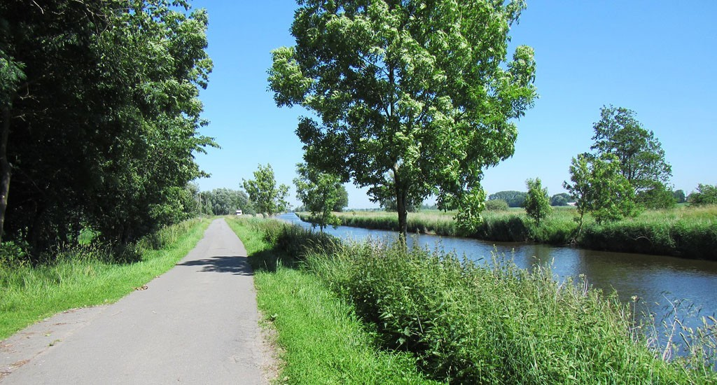 hadelner kanal mit Radweg und Bäumen an einem Schönwetter Tag.
